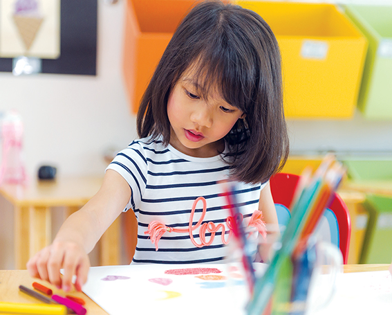 Child drawing with markers at Swan Academy