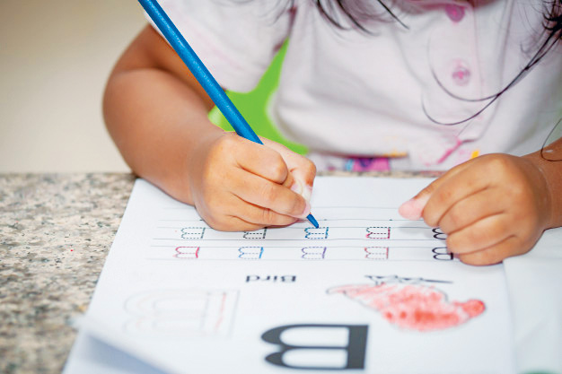 Child practising letter tracing at Swan Academy